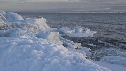 Obraz premium Ice and snow-covered natural scenery by the ocean, highlighting seasonal change