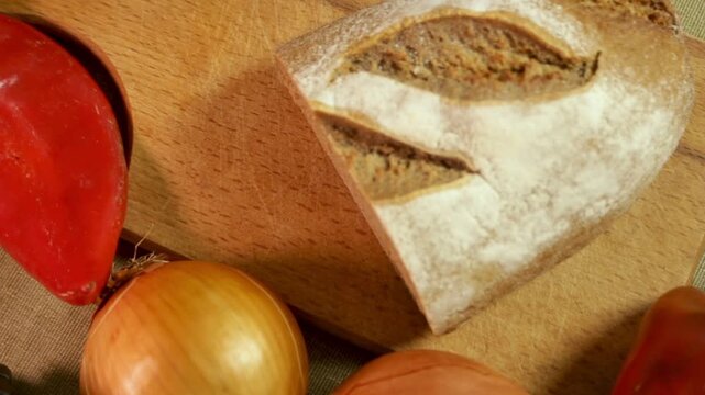 Hands slowly place bread on cutting board, emphasizing soft texture and fresh bread slice. In warm kitchen light, bread becomes part of cooking. Concept of bread and hands as kitchen ritual.