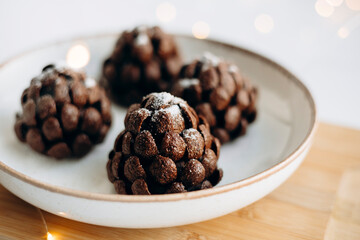 Handcrafted chocolate pine cone dessert with powdered sugar.