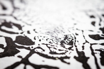 Extreme close up of black acrylic paint texture on paper. Selective focus.