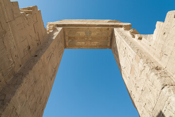 View from behind of the entrance gate of Dendera temple, Egypt, dedicated to goddess Hator. Blue sky on the background.