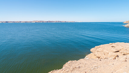 Landscape view of Nasser lake, Egypt, close to the archeological site of Abu Simbel. Blue rippled waters in the foreground. Blue sky on the background.