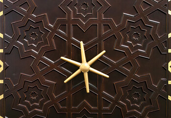 Antique closed door with a safe lock with a rotary handle in the center.