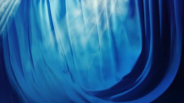 The stage curtain is blue with a textured surface and folds at the bottom. It's ready to be pulled back before a theatrical performance starts.
