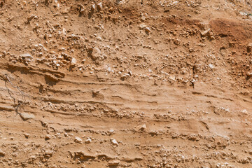 Eroded earth layers with rocks and sediments displaying geological formation