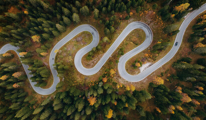 Giau Pass snake road in Italy, aerial top view of beautiful nature with bunch of green and yellow trees