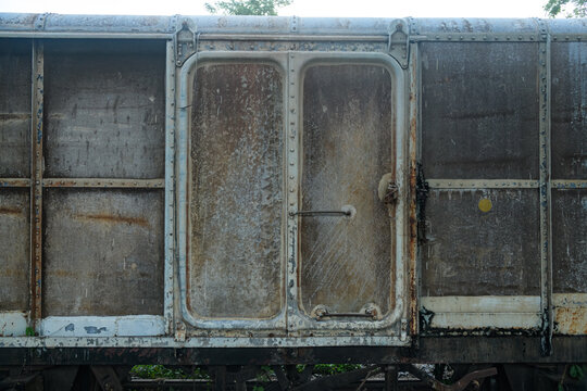 Old weathered train bogy cargo container with rust and scratches, showing aged metal textures and industrial details, perfect for concepts of history, transportation, and decay.