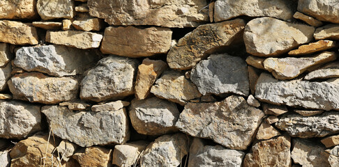 Natural stone wall as a fence in a field