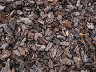 An overhead, full-frame photography capturing a rich, natural texture of pine bark mulch. This organic, rough texture is perfect for use as a seamless background or a realistic ground cover.