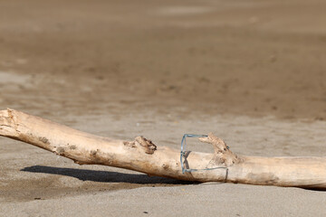 Glasses on the beach on a piece of wood 