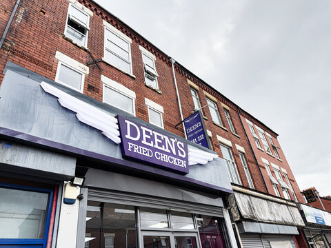Deen's Fried Chicken storefront on a brick Manchester street with a purple sign