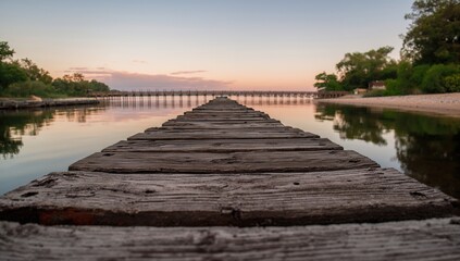 Naklejka premium Close-up of rustic wooden bridges by a serene riverbank, a peaceful evening in nature, preservation