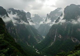 Misty mountain valley with cascading waterfalls and a winding river.