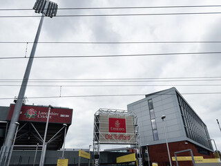 Fototapeta premium Manchester Old Trafford exterior with Emirates signage under cloudy sky and stadium lights