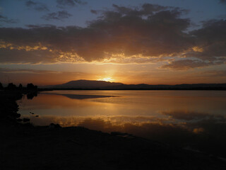 Obraz premium Golden Sunset Reflection on Calm Lake