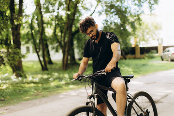 Obraz premium Young man riding bicycle in summer park