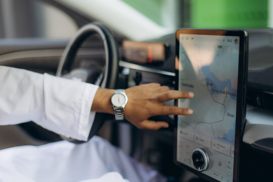 Arab man navigating global positioning system in car