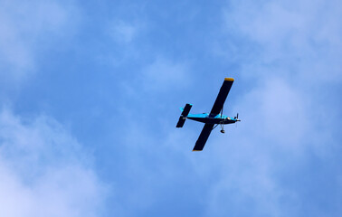 Airplane in a blue sky with a few clouds