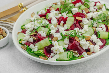 Fermented beetroot salad with cucumber, dill, pumpkin seeds, and feta cheese. A healthy winter meal