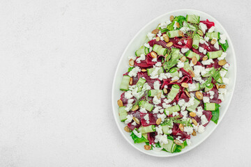 Fermented beetroot salad with cucumber, dill, pumpkin seeds, and feta cheese. A healthy winter meal