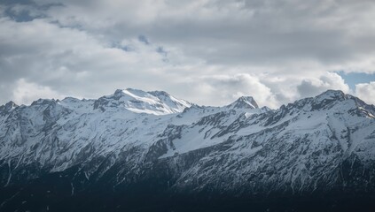 Scenic view of snow-covered peaks beneath a misty sky, highlighting seasonal change