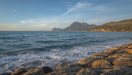 Coastal scene featuring waves crashing over rocky shoreline
