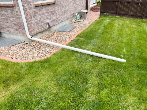 Downspout Draining Over Rock Bed into Lawn