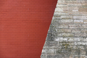 Old retro style red wall from brickwork combined diagonal with rough stone wall as background front view closeup