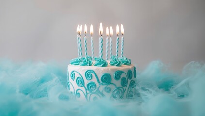 Blue birthday cake adorned with lit candles, festive celebration theme