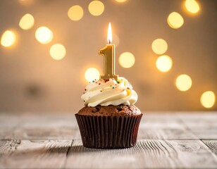 Close-up of a chocolate cupcake with frosting and a lit gold "1" candle against bokeh lights