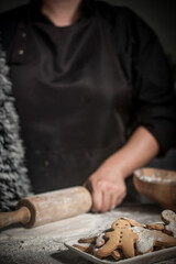 Female making festive Christmas gingerbread cookies in the home kitchen