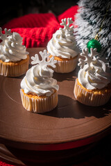 White buttercream cake decorated with snowflake toppers in a cozy Christmas and Happy New Year still life setting. The festive cake is placed on a rustic wooden table with warm light.