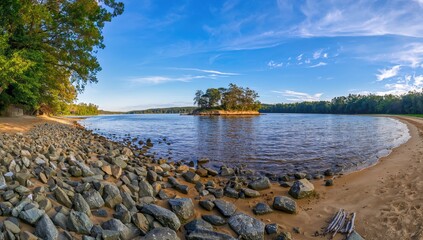 Beach with multiple rocks and trees offering shade over sandy area, serene landscape of river and trees with central island, seasonal change