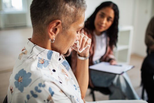 Adult person crying during group therapy in counseling room