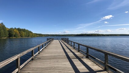 A large wooden dock extends into calm waters of a peaceful lake, emphasizing relaxation and nature appreciation