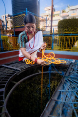 Newari Girl in tradional attire Drawing Water from a Traditional Hiti