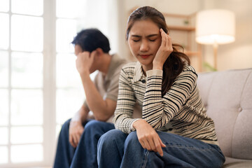 Asian adult couple face relationship problems in modern living room feel sad worry stress serious marital issues home conflict mental health challenge