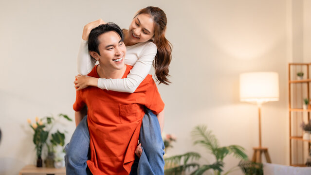 Asian Couple Enjoying Piggyback Ride at Home Playful Moment Love Connection Relaxation Indoors