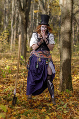 Portrait of young woman in Halloween carnival costume in autumn park.