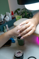 Manicurist applying nail polish to client's nails in beauty salon Stock Photo