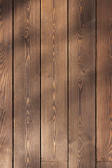 Warm brown vertical wooden planks with subtle grain texture and shadow patterns
