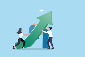 Fototapeta premium Two business people working together to push a large green upward trending arrow symbolizing growth and success