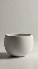 Smooth, round, matte white ceramic container rests against a minimalist, light gray background