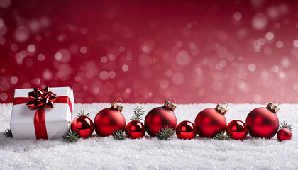 Christmas red baubles and gift box on snowy background with snow bokeh