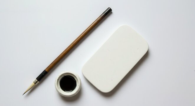 Traditional writing instruments for Eastern calligraphy are arranged on a clean, bright surface