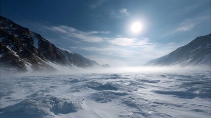Fototapeta premium A dramatic frozen mountain landscape under a bright hazy sun with blowing snow