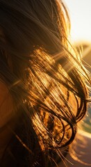 Bright golden sun flares intensely through strands of dark brown hair outdoors.