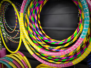 Display of colorful hula hoops hanging against a dark background in a sports store