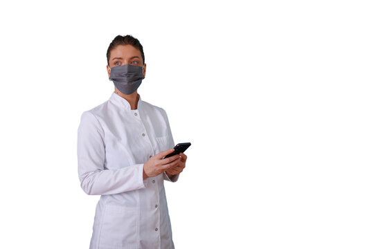 Healthcare professional woman wearing face mask and lab coat, holding smartphone, looking sideways, transparent background