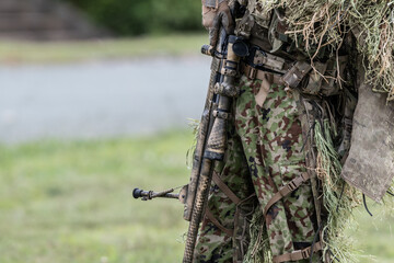 Obraz premium ギリースーツを着て狙撃銃を構える軍人